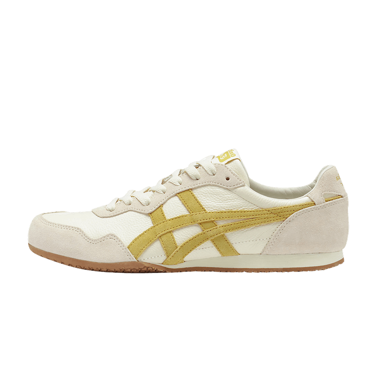 Onitsuka Tiger Serrano zijaanzicht, crèmekleurig leer met geel suède strepen en gumzool