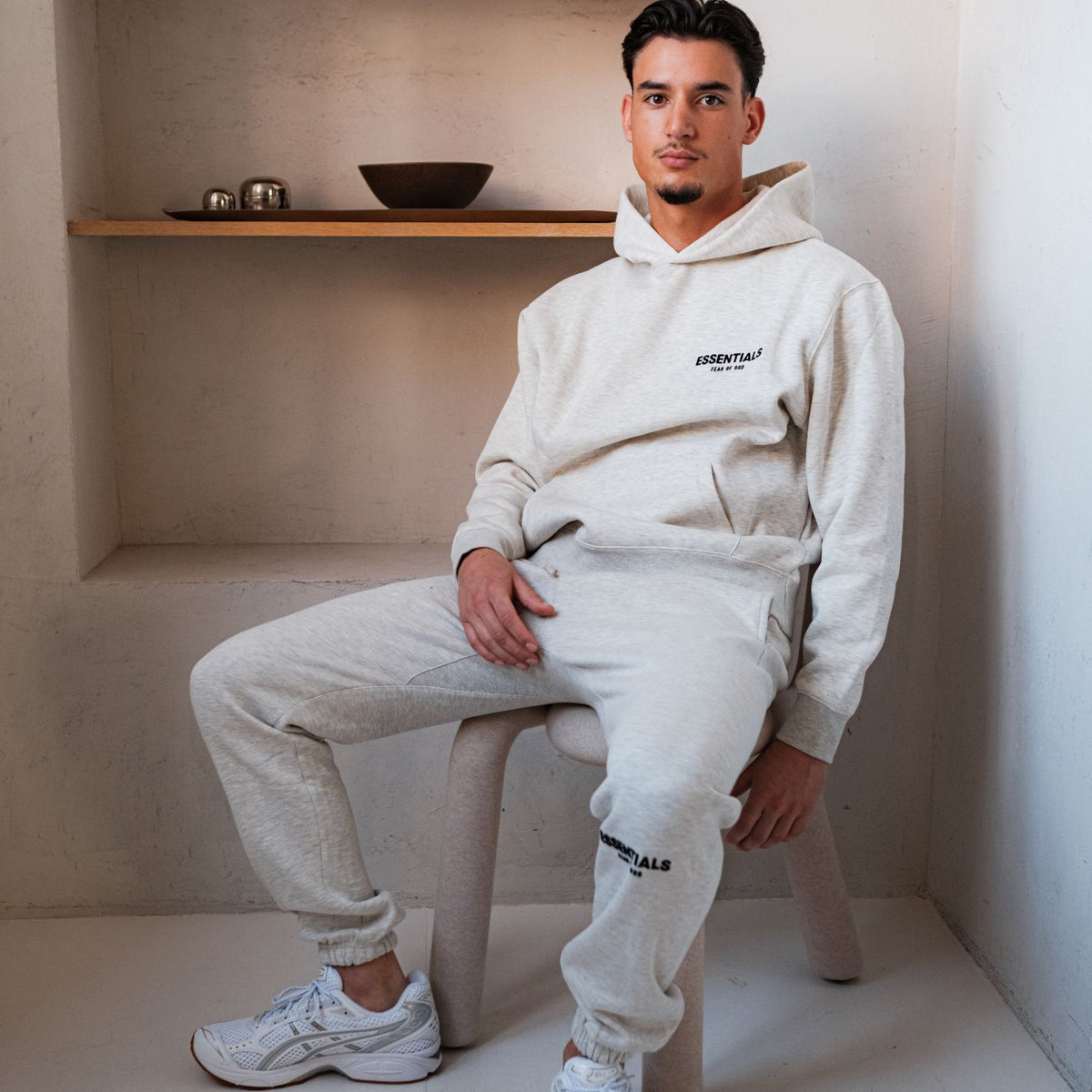 Fear of God Essentials Light Oatmeal Hoodie, gedragen met bijpassende joggingbroek en klein logo op borst