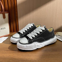 Black low-top sneakers with thick white textured soles and white laces, showcasing Maison Mihara Yasuhiro Peterson OG Sole Canvas Low Black, exclusive in Europe, the real deal.