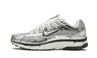Nike P-6000 Metallic Silver, zijaanzicht met zichtbare metallic zilveren panelen, zwarte stiksels en witte zool